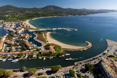 Aerial view on blue water of Gulf of Saint-Tropez, sail boats, houses of Port Grimaud and Port Cogolin, summer vacation in Provence, France
