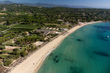 Saint-Tropez yakınlarındaki efsanevi Pampelonne plajı ve mavi deniz manzarası Fransız Rivierası 'nın beyaz kumlu sahillerinde yaz tatili.