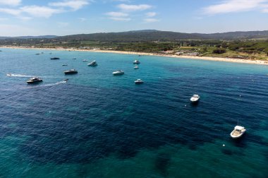 Saint-Tropez yakınlarındaki efsanevi Pampelonne plajı ve mavi deniz manzarası Fransız Rivierası 'nın beyaz kumlu sahillerinde yaz tatili.
