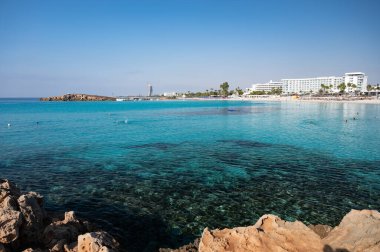 Kıbrıs Rum Kesimi 'nin Ayia Napa plajındaki Akdeniz üzerinde mavi kristal berrak su üzerindeki hava panoramik manzarası. Deniz tatili.