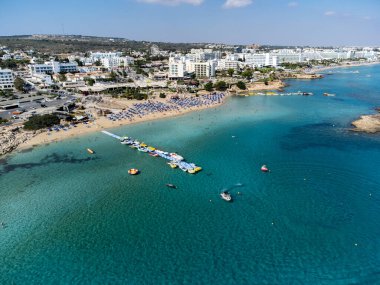 Villalar, tatil beldeleri ve Akdeniz 'deki kumlu incir ağacı plajı, Protaras, Kıbrıs Rum Kesimi yakınlarındaki mavi kristal berrak su üzerindeki hava panoramik manzarası