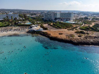 Kıbrıs Rum Kesimi 'nin Ayia Napa plajındaki Akdeniz üzerinde mavi kristal berrak su üzerindeki hava panoramik manzarası. Deniz tatili.