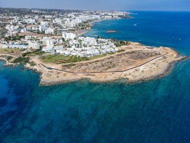 Villalar, tatil beldeleri ve Akdeniz 'deki kumlu incir ağacı plajı, Protaras, Kıbrıs Rum Kesimi yakınlarındaki mavi kristal berrak su üzerindeki hava panoramik manzarası