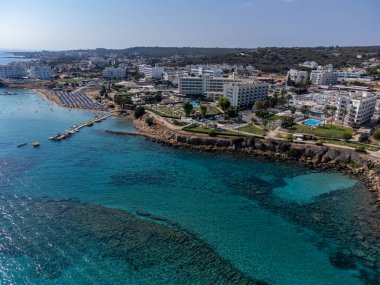 Villalar, tatil beldeleri ve Akdeniz 'deki kumlu incir ağacı plajı, Protaras, Kıbrıs Rum Kesimi yakınlarındaki mavi kristal berrak su üzerindeki hava panoramik manzarası