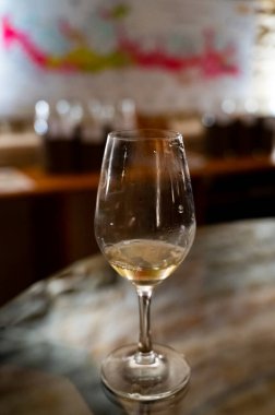 Wine tasting in underground cellars caves of French wine domain in Puligny-Motrachet village, Burgundy, France with map of Burgundy wine appelations and soils on background.