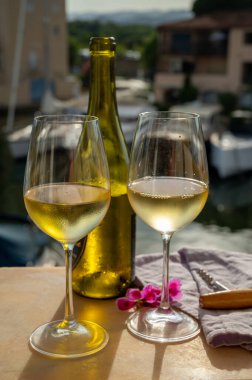 Port Grimaud 'un yat limanında manzaralı soğuk beyaz şarap içmek, Fransa' nın Provence şehrinde Fransız Rivierası 'nda yaz tatili