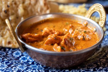 Indian style food, chiken tikka masala curry dish served with rice and garlic bread naan, close up