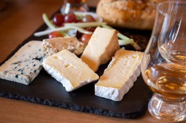 Pairing of scotch whiskies and farmers scottish cheeses cheddar, stilton, blue cheese, brie, tasting of whiskey and cheese in Edinburgh, UK