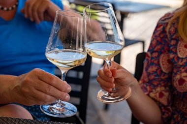 Pouring of txakoli or chacol slightly sparkling very dry white wine produced in Spanish Basque Country, served outdoor with view on Bay of Biscay, Atlantic Ocean