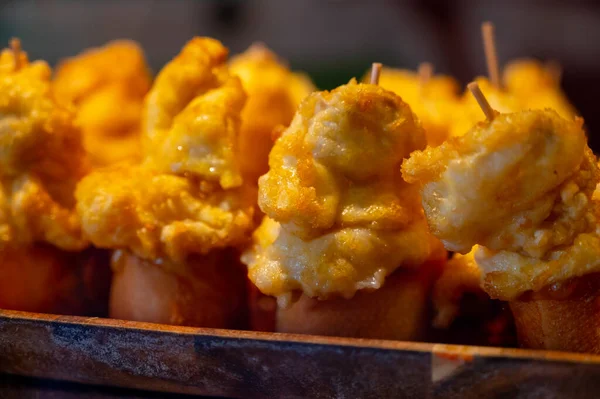 Typical snack in bars of Basque Country and Navarre, pinchos or pinxtos, small slices of bread upon which ingredient or mixture of ingredients is placed and fastened with toothpick, San Sebastian, Spain, close up