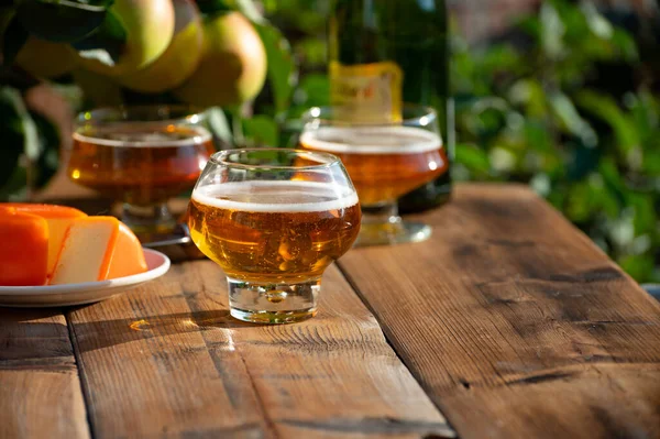 Food and drink pairing, apple cider in glasses produced on organic farm from bio apples in Normandy, France and farmers cheddar cheese from England