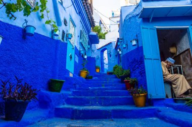 Chefchaouen, Fas, 20 Ağustos 2018: Mavi kasabanın merdivenlerinde dinlenen yaşlı adam