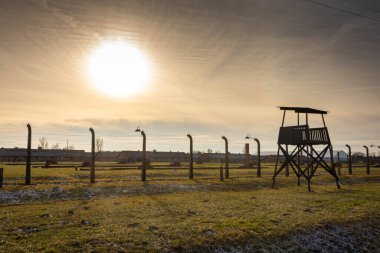 AUSCHWITZ BIRKENAU. POLAND, 9 HAZİRAN 2022: Günbatımında Auschwitz II Birkenau Nazi İmha Kampı 'nda nöbet kulesi