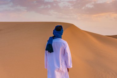 Merzouga, Fas 'taki Sahra Çölü' nde geleneksel berber kıyafeti giyen genç bir Arap.