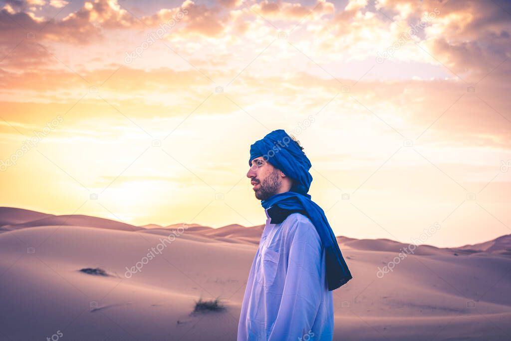 Young arabic man wearing traditional berber clothes in the Sahara Desert of Merzouga, Morocco