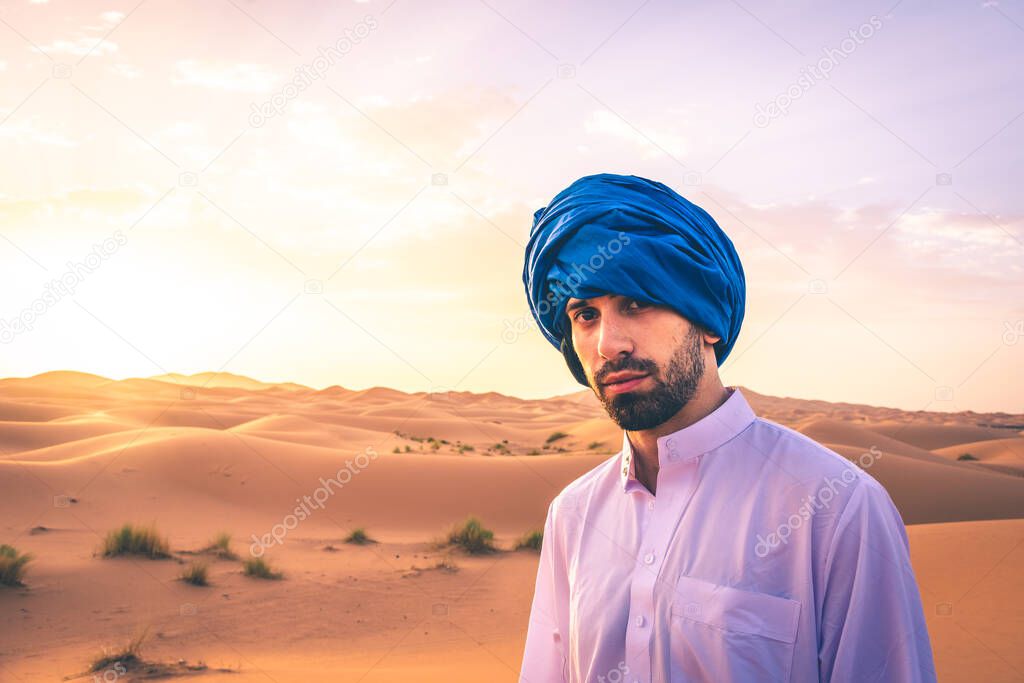 Young arabic man wearing traditional berber clothes in the Sahara Desert of Merzouga, Morocco
