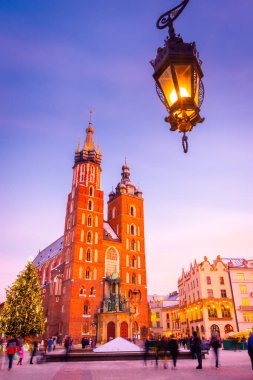 KRAKOW, POLAND, 7 HAZİRAN 2022: Rynek Glowny Meydanı 'ndaki St. Mary Bazilikası üzerinde gün batımı