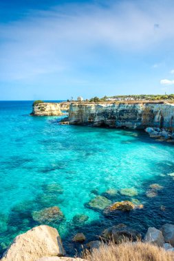 SALENTO, İtalya, 11 AĞUSTOS 2021: Apulia 'nın güzel kristal berraklığı kayalıklardan ve Sant' Andrea 'nın deniz yığınlarından
