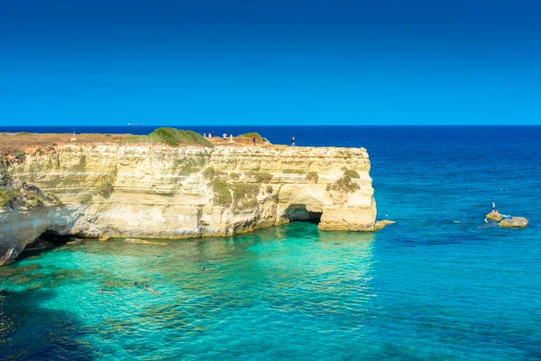 SALENTO, İtalya, 11 AĞUSTOS 2021: Apulia 'nın güzel kristal berraklığı kayalıklardan ve Sant' Andrea 'nın deniz yığınlarından