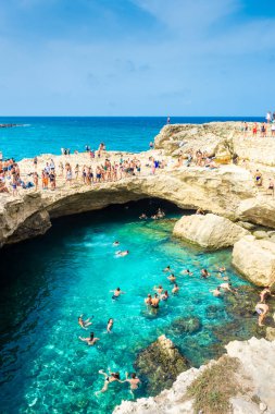 SALENTO, İtalya, 11 AĞUSTOS 2021: Grotta della Poesia 'nın berrak sularına dalan insanlar (Şiir Mağarası)