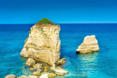 Salento, Apulia, İtalya 'nın berrak sularında Sant' Andrea 'nın güzel kayalıkları ve deniz yığınları