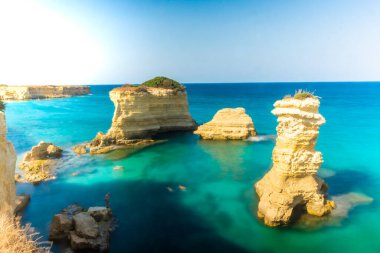 SALENTO, İtalya, 11 AĞUSTOS 2021: Apulia 'nın güzel kristal berraklığı kayalıklardan ve Sant' Andrea 'nın deniz yığınlarından