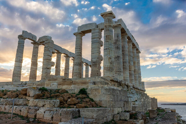 Храм Посейдона на мысе Сунион на закате, над Эгейским морем в Греции