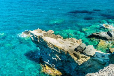Papafragas, Milos Adası, Yunanistan 'ın kayalıklarından süzülen inanılmaz kristal berraklığında su