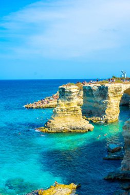 SALENTO, İtalya, 11 AĞUSTOS 2021: Apulia 'nın güzel kristal berraklığı kayalıklardan ve Sant' Andrea 'nın deniz yığınlarından