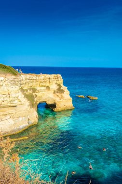 SALENTO, İtalya, 11 AĞUSTOS 2021: Apulia 'nın güzel kristal berraklığı kayalıklardan ve Sant' Andrea 'nın deniz yığınlarından