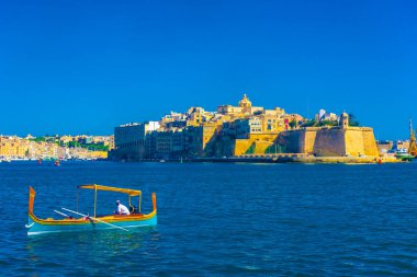 Birgu, Malta, 22 May 2022: Traditional boat in front of the Castle of Birgu, one of the Three Cities of Malta