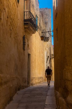 Mdina, Malta, 21 Mayıs 2022: Eski Medine şehir merkezinin sokaklarında yürüyen yaşlı adam