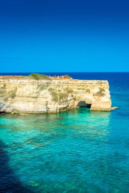 SALENTO, İtalya, 11 AĞUSTOS 2021: Apulia 'nın güzel kristal berraklığı kayalıklardan ve Sant' Andrea 'nın deniz yığınlarından