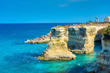 SALENTO, İtalya, 11 AĞUSTOS 2021: Apulia 'nın güzel kristal berraklığı kayalıklardan ve Sant' Andrea 'nın deniz yığınlarından