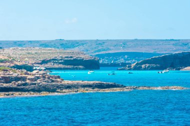 Comino, Malta, 22 May 2022: Tourists swimming in the crystal clear water of the Blue Lagoon