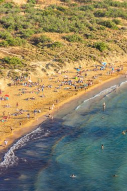 Mellieha, Malta, 21 Mayıs 2022: Ghajn Tuffieha sahilindeki insanlar
