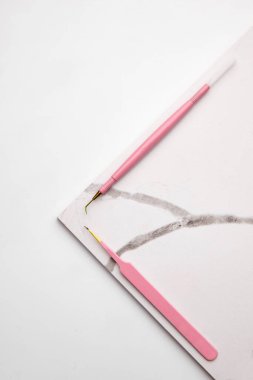 Kirpik Uzatma Prosedürü için araçlar. Mermer tabakta iki araç. Beyaz arka plan. Güzellik ve moda konsepti.