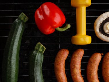 Dambıl, dolmalık biber, kabak kabağı, mantar ve ızgarada sosis. Uygun barbekü partisi konsepti, sağlıklı ya da kötü diyet seçimi, fitness yaşam tarzı spor salonu kompozisyonu.