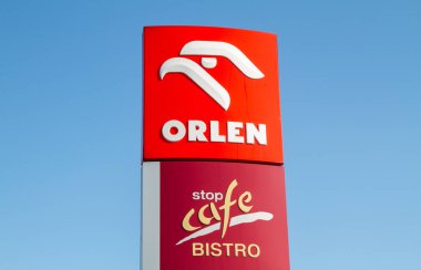Krakow, Poland - March 27, 2022: Orlen and Stop Cafe Bistro sign outside a petrol station. Logo at filling gas station forecourt pylon.