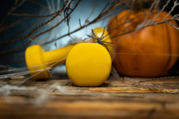 Zwei Gelbe Gymnastikhanteln Und Herbstkürbis Hintergrund Bedeckt Mit Spinnennetz Gesunder — Stockfoto