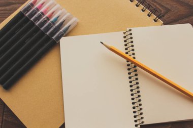 Ahşap bir masanın üzerinde duran kalem ve kalemler..
