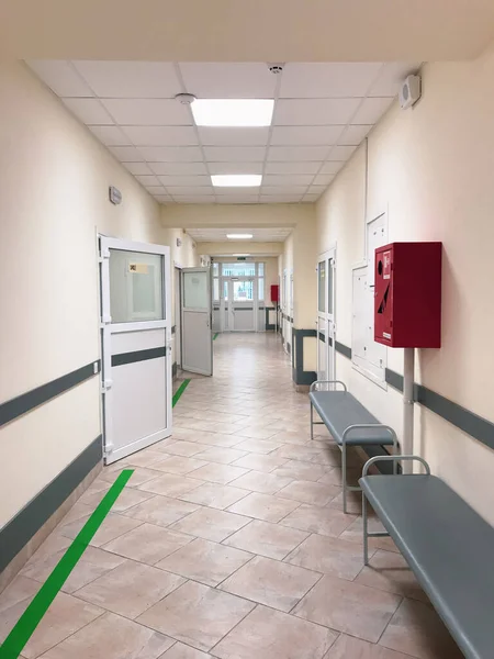 Corridor in the middle of the hospital with the door open.