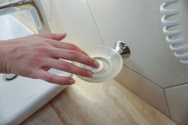 A piece of soap in a white dish. Soap in soap dish, elevated view. Bathroom.