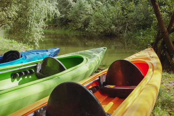 在河岸划船用的小船 夏天的娱乐活动 多彩的皮划艇在河岸上 在皮划艇上打斗 蓝皮划艇 — 图库照片