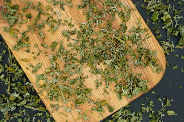 Dried mint leaves on a wooden background. Close up of dried mint leaves tea. Mint is dried on a cutting board. Mint for medicinal tea.