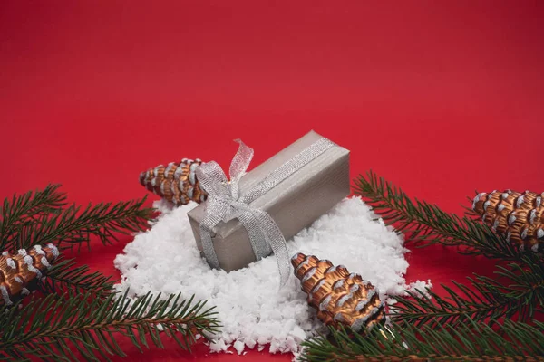 Gray Christmas box on a red background. Creative christmas concept.