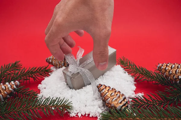 Kleine Grijze Kerstgeschenkdoos Kerstcadeau Sneeuw Een Rode Achtergrond Hand Kerst — Stockfoto