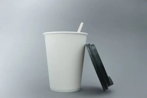 White paper cup. Place for text. A paper cup on a gray background.