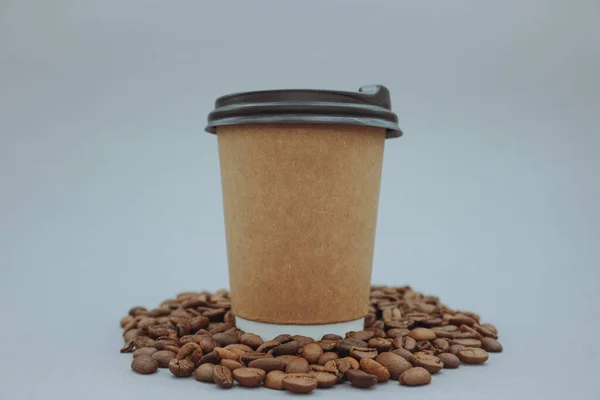 Coffee paper cup isolated. Coffee beans and a paper cup on a gray background.
