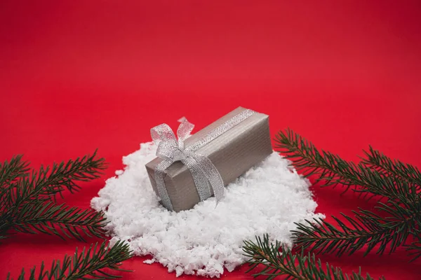 Невеликий Новорічний Подарунок Снігу Червоному Тлі Маленька Сіра Подарункова Коробка — стокове фото